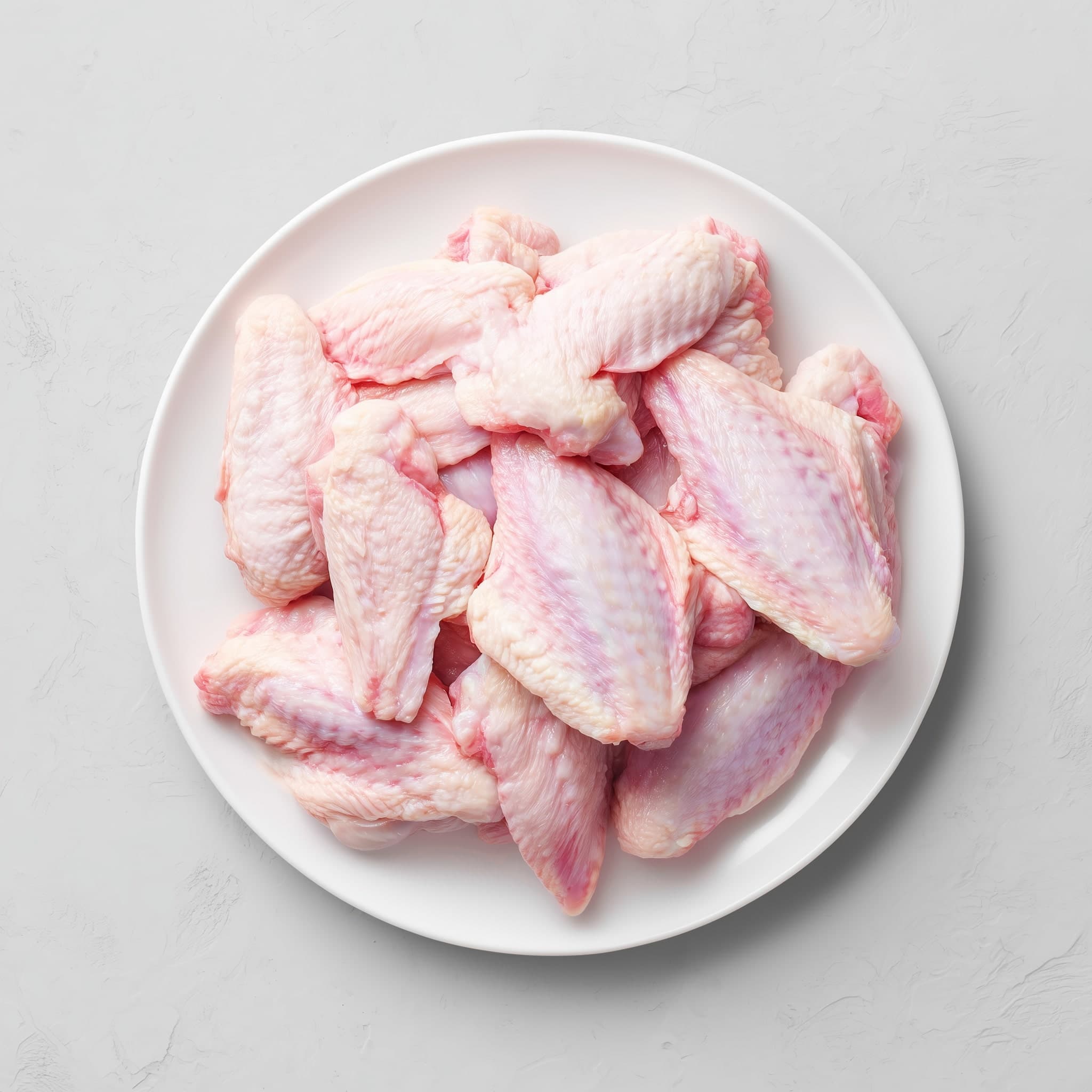 1 kg of graded frozen chicken wings on a plate — Nextekci