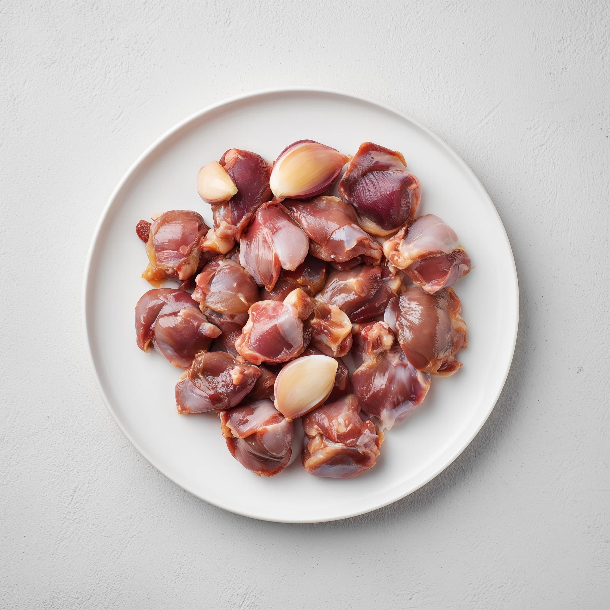 1 kg of cleaned frozen chicken gizzards on a plate — Nextekci